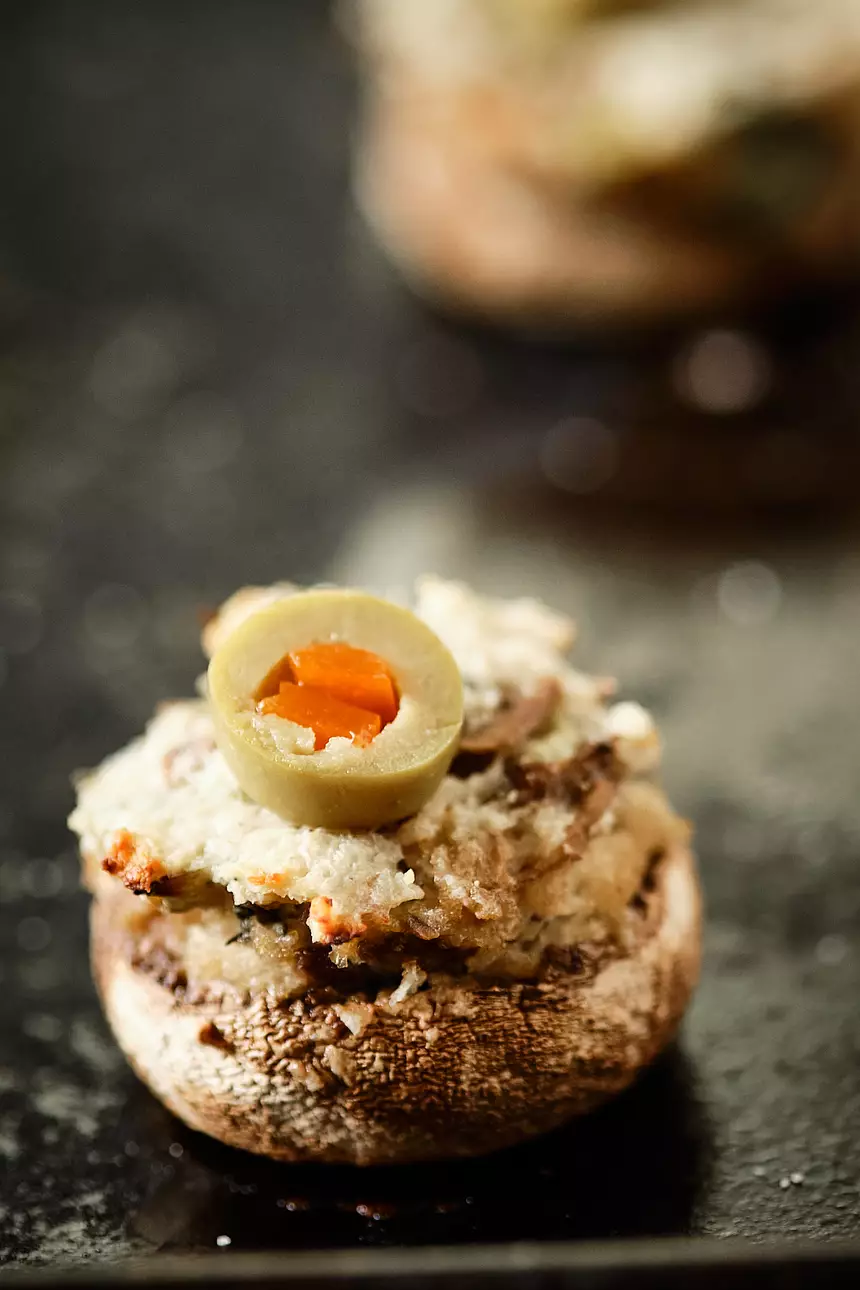 Close-up of an awesome stuffed mushroom topped with an olive slice
