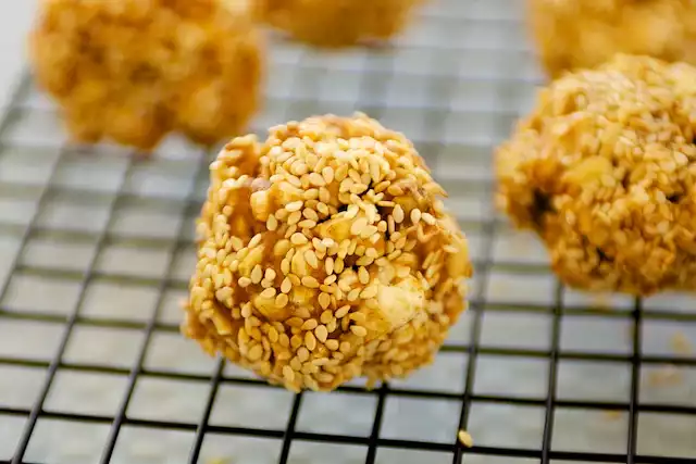 Double Peanuts and Honey Christmas Popcorn Balls with Sesame Coating